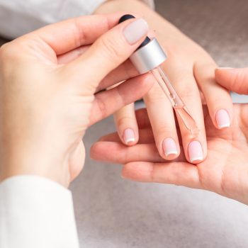 manicurist-pours-oil-nails-woman